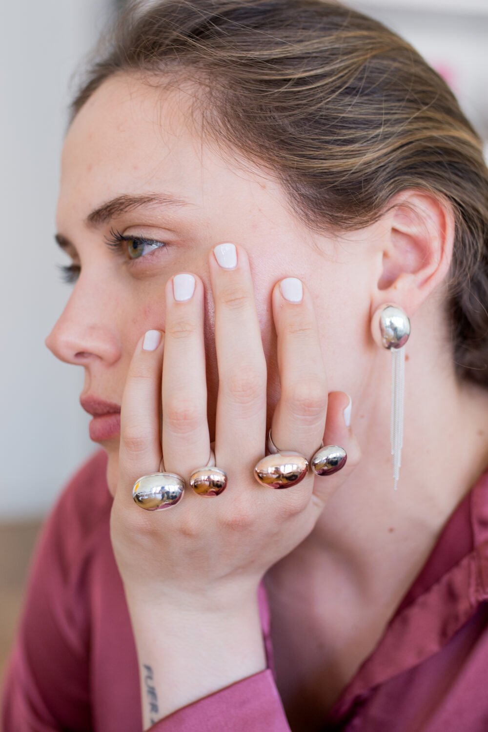 Retrato con varios anillos de Carlota Guardia apoyados en el rostro