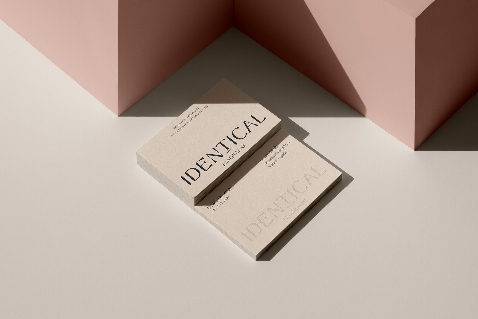 Cajas de perfume de Identical sobre planos de color rosa