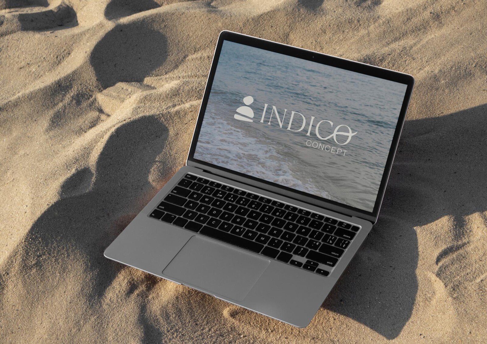 Portátil con la web de Indico Concept sobre la arena