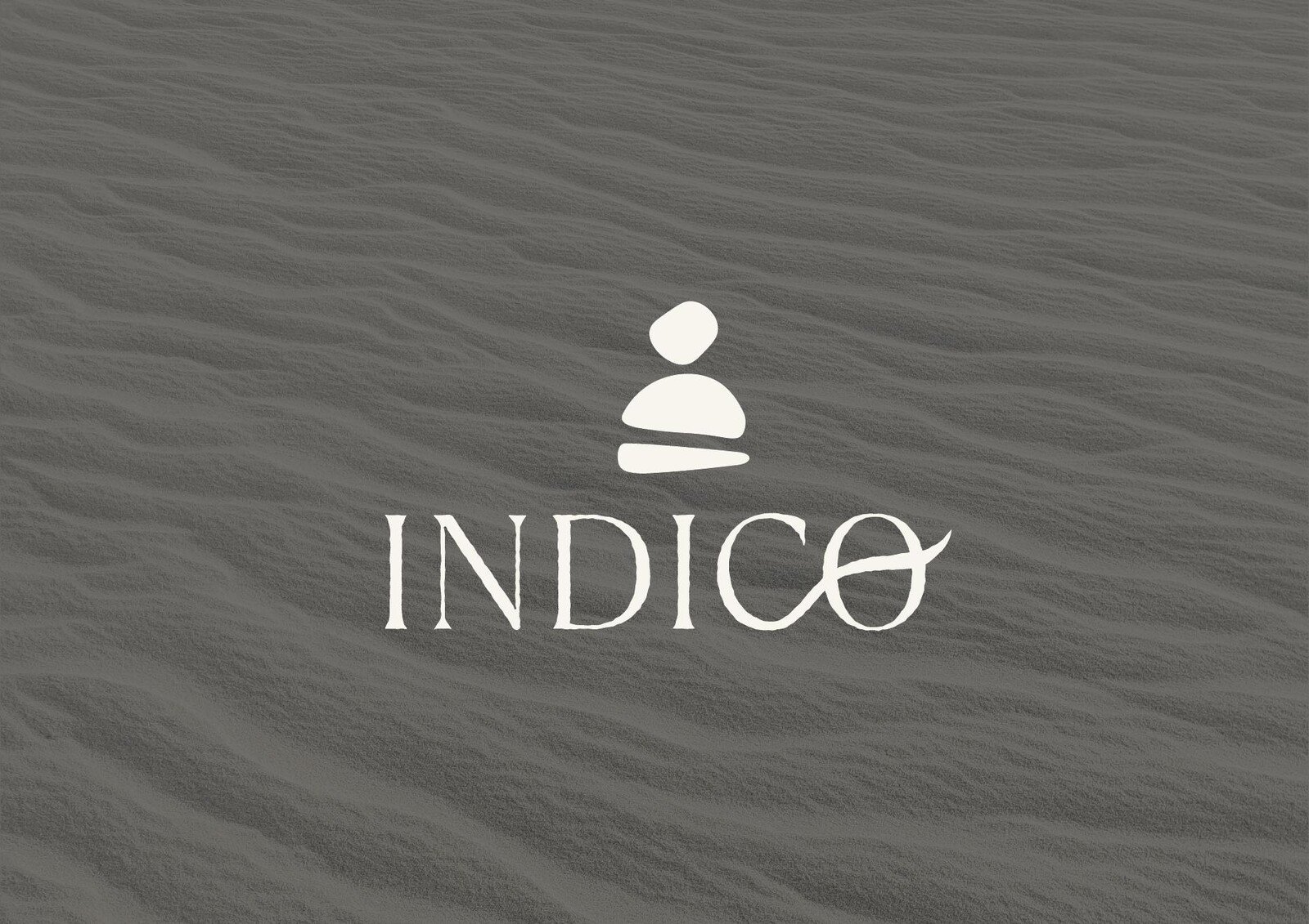 El logotipo de Indico sobre arena en tono gris