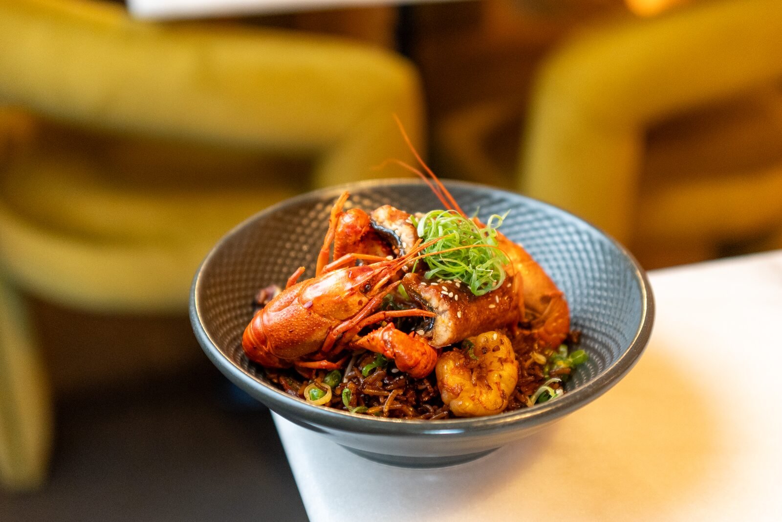 Arroz con mariscos y langostino servido junto a butacas mostaza